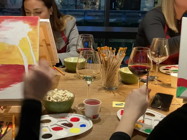 Painting at the table, with wine, brushes and palettes