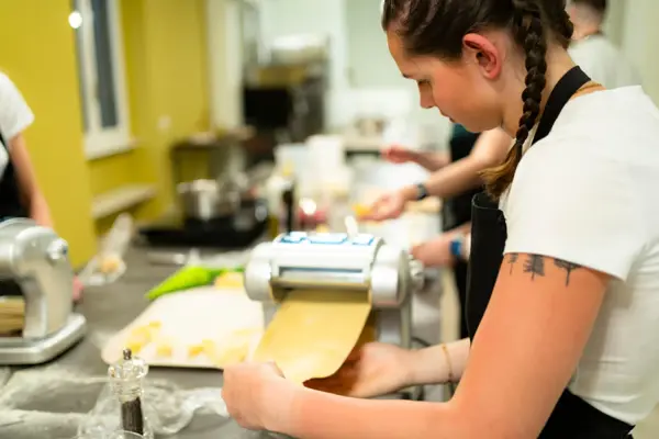 Rolling fresh pasta through the machine during the cooking class